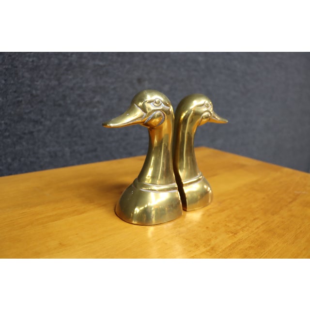 Charming pair of vintage solid brass bookends designed in the form of stylized ducks with elongated necks and gently...