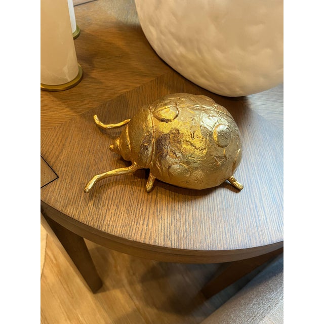 Add a touch of whimsical charm to any vignette with a Wisteria insect in shiny gold finish.