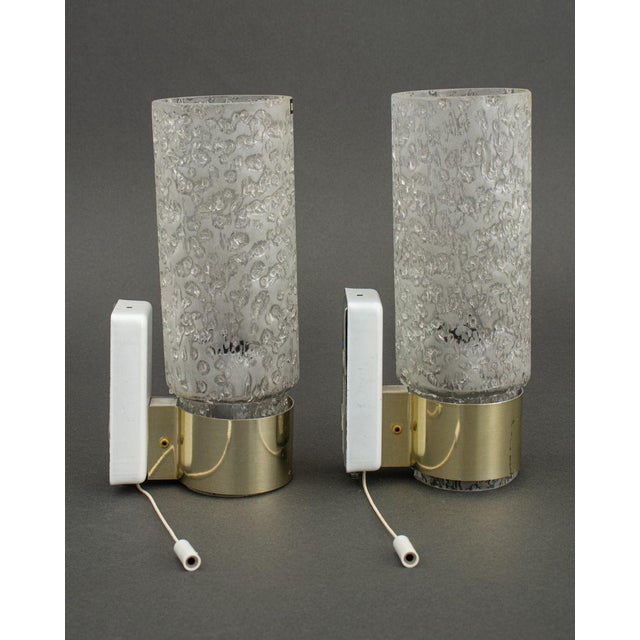 Pair of Doria Leuchten Germany Glass and Brass Sconces, having textured frosted glass cylindrical shade and pull string...