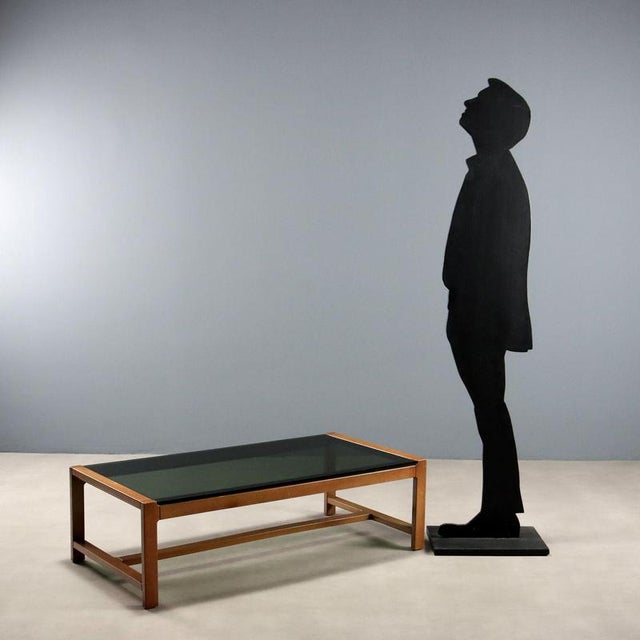 Coffee table, stained beech wood, smoked glass top. This piece is attributed to the mentioned designer/maker. It has no...