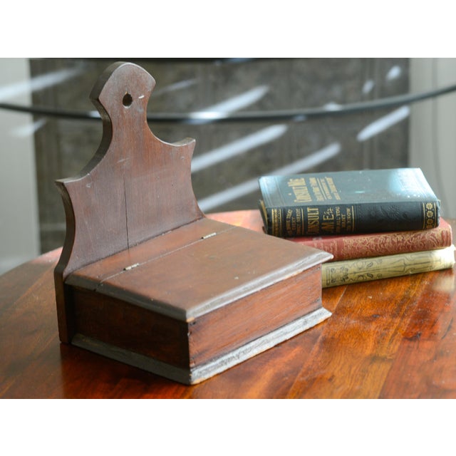 Vintage wooden primitive hanging salt box with a reticulated edge. Measures 10.5" H x 7.25 Dx 8.25" wide. Has stickers for...