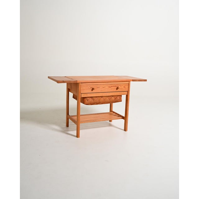 Pine coffee table with extendable top, drawer, woven basket, and lower shelf. Scandinavian production, 1950s. Made in...