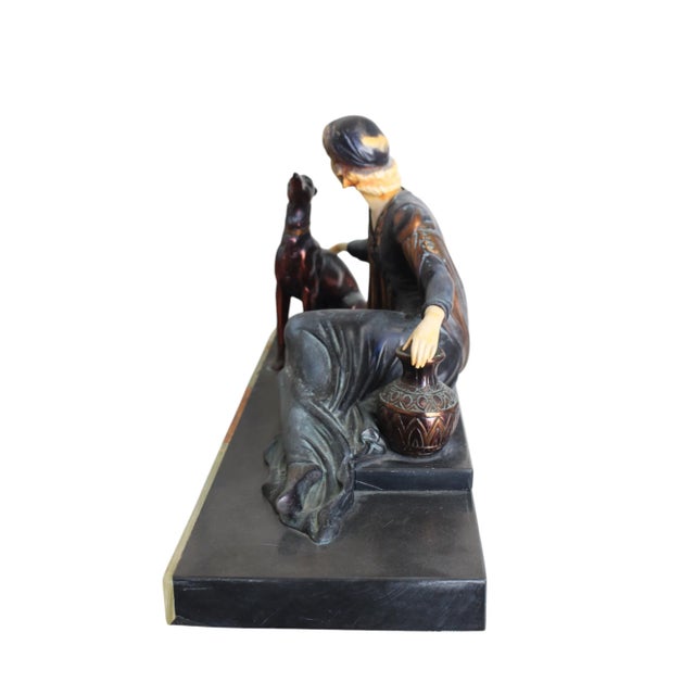 Elegant and iconic French Art Deco group featuring a reclining lady in a flapper dress with two sleek greyhounds, modeled...