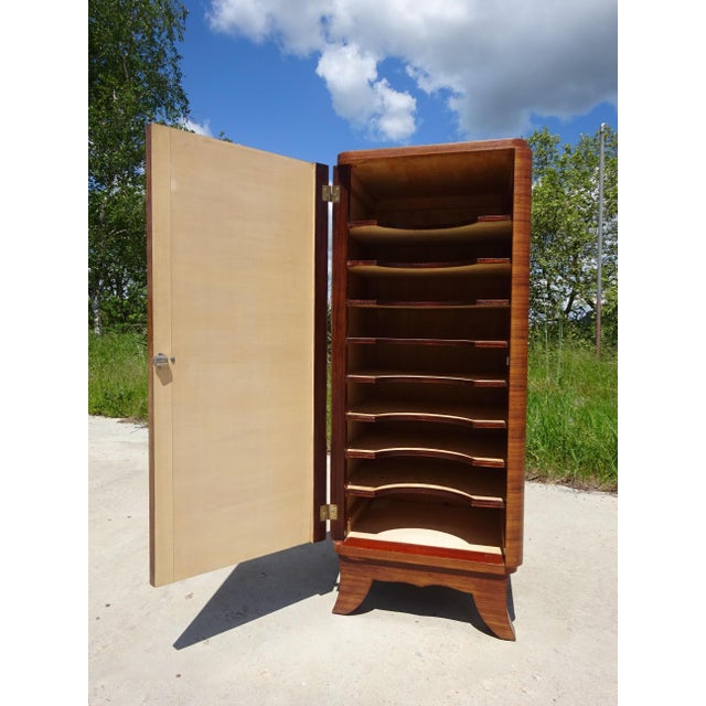 A tall, narrow cabinet with rounded front corners, designed to hold 33 RPM vinyl records, but could be repurposed as an...