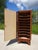 A tall, narrow cabinet with rounded front corners, designed to hold 33 RPM vinyl records, but could be repurposed as an...