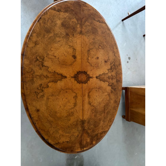 A striking 19th-century English Victorian tilt-top center table, circa 1850, crafted in beautifully figured burr walnut...