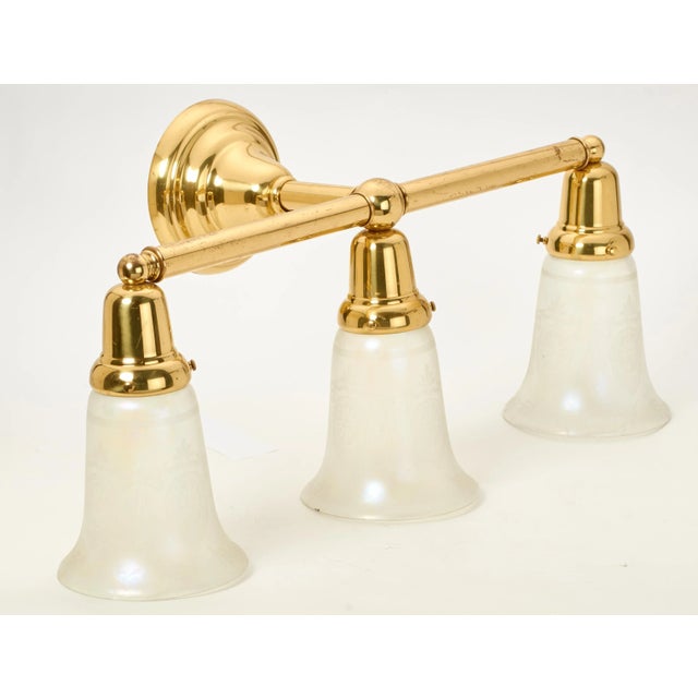 Classy traditional polished brass vanity light. Includes 3 French style etched glass bell shades.