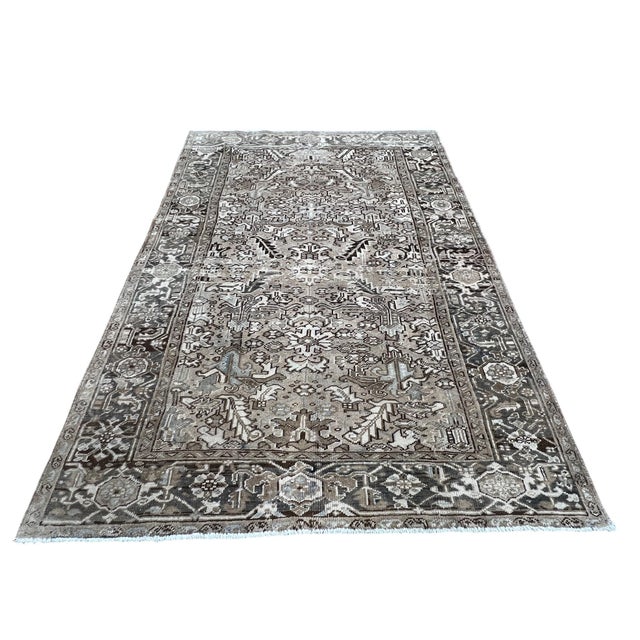 Vintage Persian Heriz rug, hand knotted in Iran from 100% wool. Measuring 6’3” x 8’11”, the rug features a bold geometric...