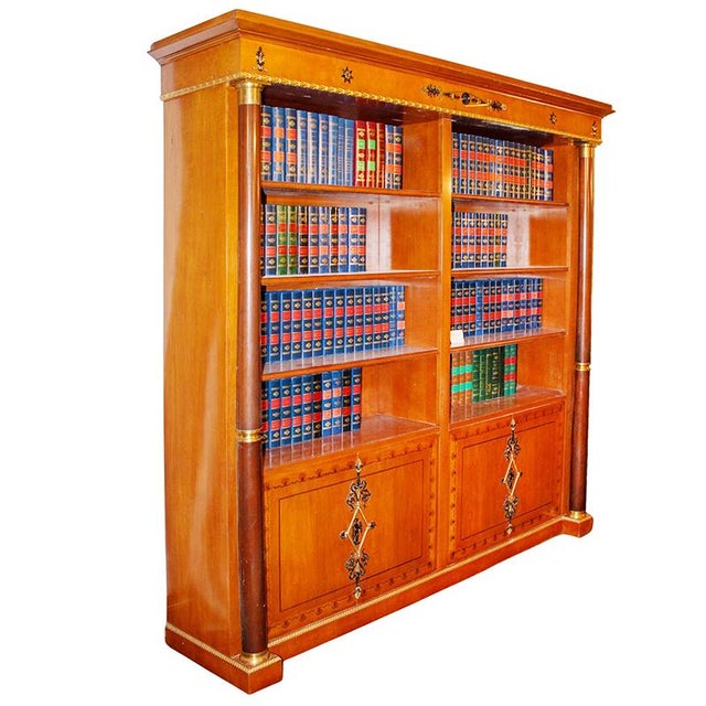 Empire-style cherry bookcase, open front with various compartments and four doors underneath, decorated with gilded and...