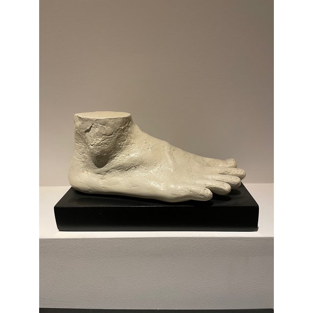 Plaster foot sculpture. Set of 2. Left and right foot. On black wood pedestal. Perfect as decorative accents in the manner...