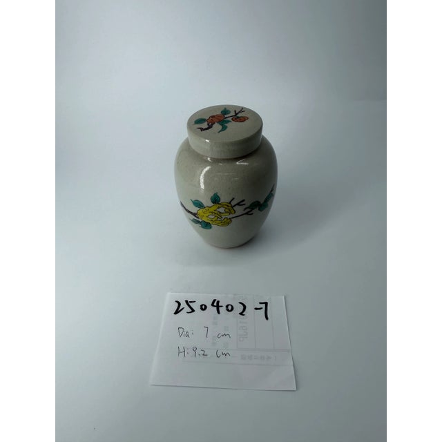 An exquisite antique Japanese porcelain tea caddy, traditionally used for storing fine tea leaves. The jar features a...