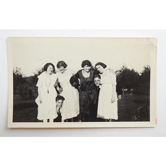 Early 20th century snapshot photograph of girls with guys in a headlock. Unframed, small corner crease.