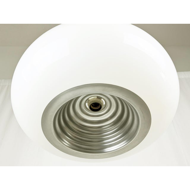 This out of production pendant was made from a white opaline glass shade with a shaped silver aluminum reflector. The lamp...