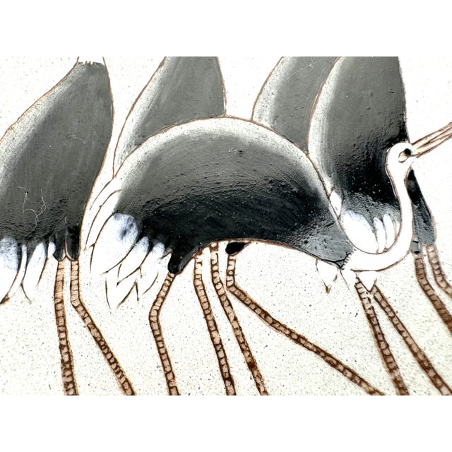 This striking hand-decorated porcelain bowl by Nora Fenton features an elegant depiction of cranes in a serene palette of...