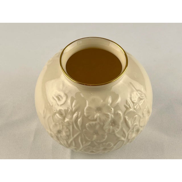 Elegant ivory ceramic vase with gold on rim and base. The embossed flowers surround all sides of the vase. Excellent...