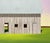 This oil on canvas artwork depicts a minimalist barn set against a softly colored sky, emphasizing a serene and tranquil...