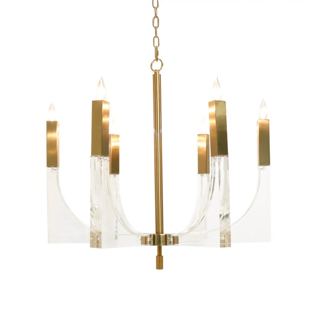 The Omeara chandelier features six candle-style lights, each perched on a sharp, angular lucite base connected to a...