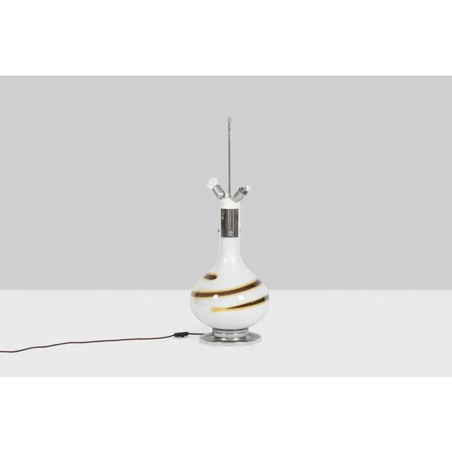 White glass lamp decorated with a brown and yellow spiral, baluster shape. Base and top of the lamp in chromed metal....