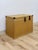This vintage woven chest showcases a light, blonde wicker finish paired with distinctive brass clamp hardware, offering a...