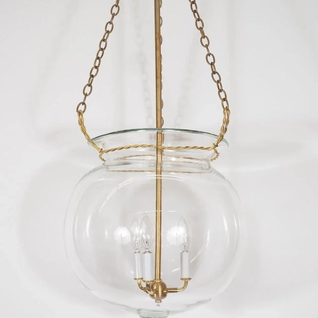 "Fishbowl" glass and brass pendant with wrought details. Creator: Marcelo Bessa Manufacturer: Spark Interior Origin:...
