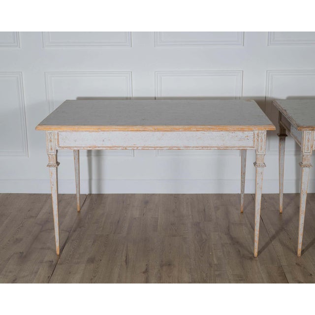 A rare and elegant pair of Gustavian style tables, repainted in a soft light gray that enhances their timeless...