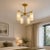 Add a warm architectural presence to your interior with this handcrafted 4-light brass chandelier, designed with four...