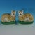 Pair of Staffordshire Pottery figures which feature a cat on a cushion, recumbent on an oval base. Dull gilt base line and...