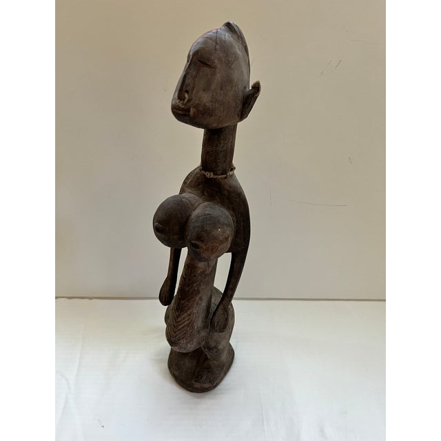 Antique African Carved Wood Fertility Statue with exagerated features. This piece is carved from one piece of wood and has...