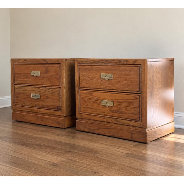 Authentic vintage Thomasville campaign-style nightstands featuring rich oak grain, distinctive architectural lines, and...