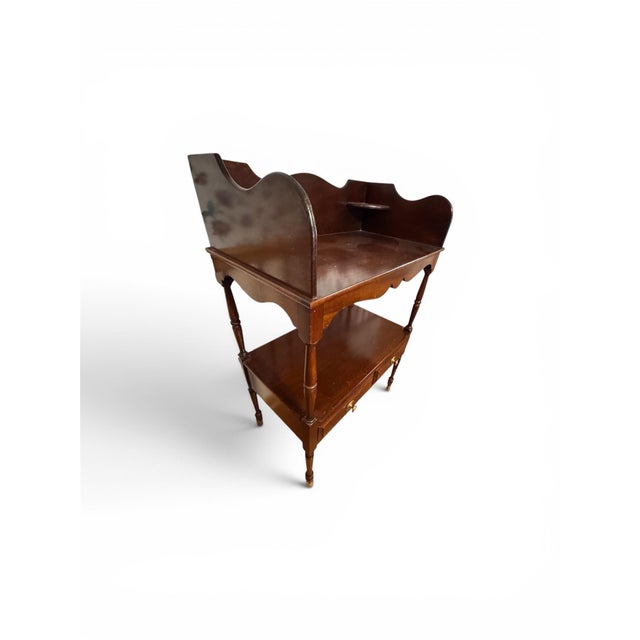 Sheraton-style mahogany wash stand featuring a shaped backsplash with corner shelves, a lower shelf with two paneled...