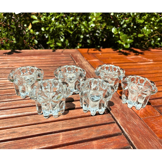 Like little sculpted flowers frozen in crystal-clear glass, this charming set of six French candle holders plays...