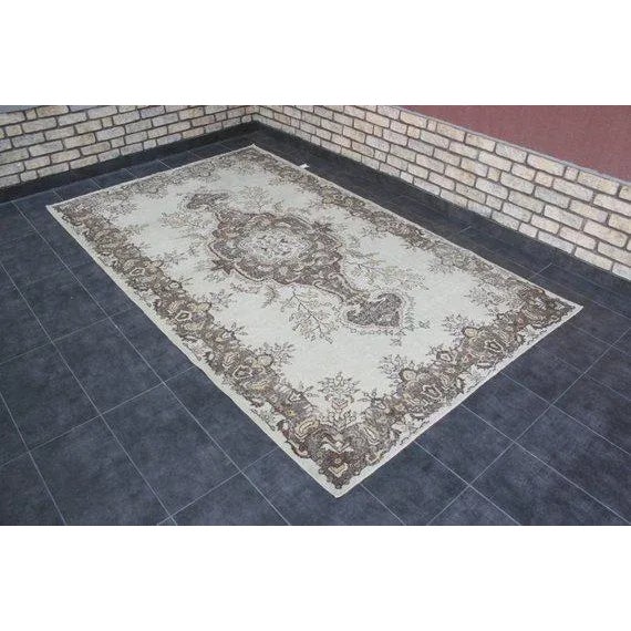 This is a vintage Turkish Oushak rug from the 1960s. The piece was hand-knotted.