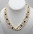 1980s goldtone spherical faux-ivory beads with faux-tiger's eye accents torsade necklace with oval cabochon faux-ivory at...