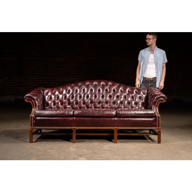 c. 1970s/1980s; Leathercraft, Inc. - Conover, NC Elegant tufted camelback sofa upholstered in oxblood red leather with...
