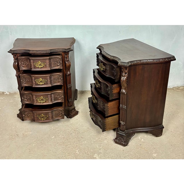 Elegant pair of French Louis XV style bedside chests featuring a richly carved bombe form and ornate brass hardware. Each...