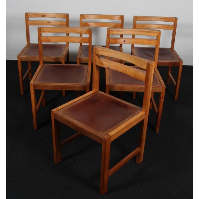 Knud Færch dining chairs in solid pine. Seat with saddle leather. Made by Sorø Stolefabrik. This piece is attributed to...