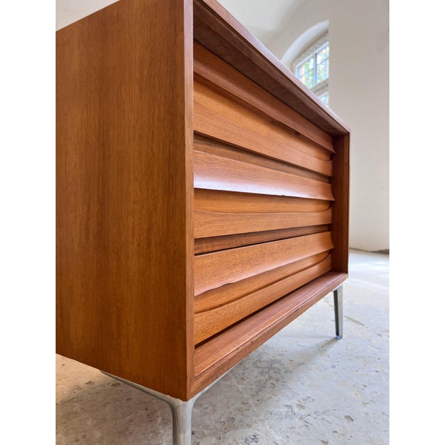 This striking chest of drawers, crafted from exquisite walnut, is a fantastic example of mid-century German furniture...