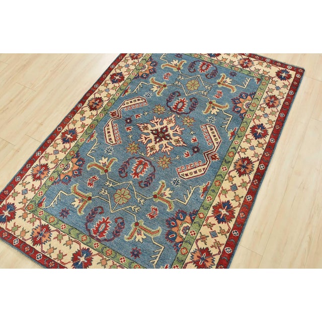 A tribal Caucasian Kazak rug hand-knotted with an all-wool pile on a cotton foundation. This oriental rug features a...