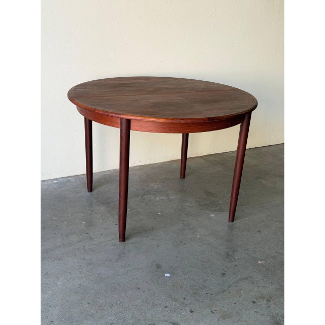 Classic vintage Danish Mid Century Modern round dining table crafted in warm teak. The clean circular top and tapered legs...