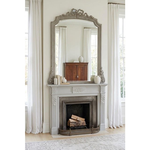 An attractive turn-of-the-century french rococo-inspired overmantel mirror, dating to circa 1900. This elegant piece...