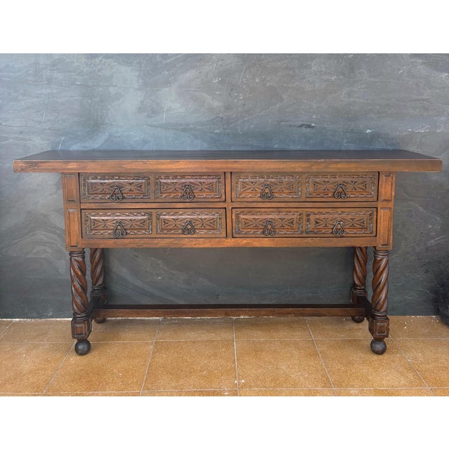 Spanish Renaissance Revival console table featuring four carved drawers and distinctive spiral turned front legs. The...