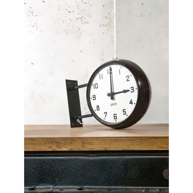 A double-sided slave clock by Gents of Leicester from the 1940s, in a Bakelite housing on a steel wall bracket, readable...