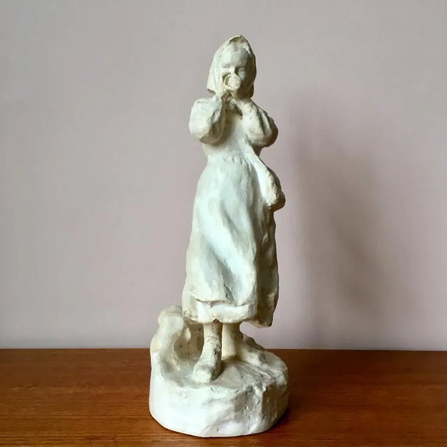 This large plaster figurine is signed and dated 1917 and features a very nice patina and a text on the underside.