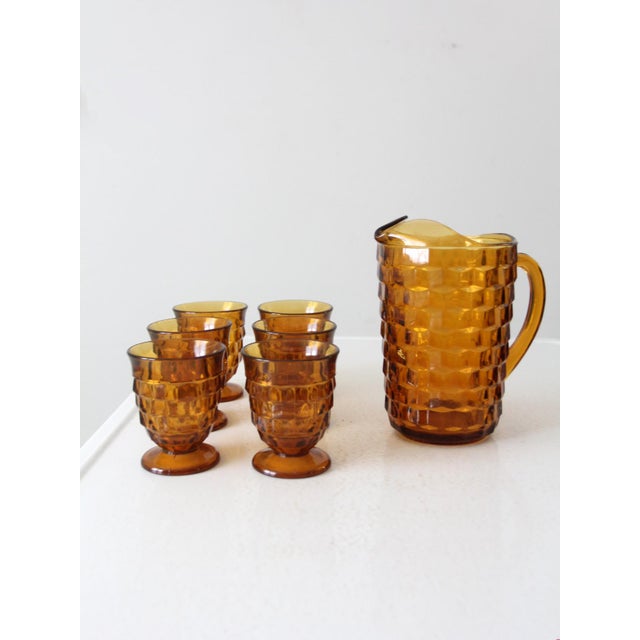 This is a mid-century amber glass pitcher and tumblers set. Attributed to Colony from their Whitehall Amber line, the...