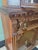 Gorgeous ornate carved wood hutch featuring glass doors, unique two finger brass pulls, floral embossed brass knob, and...