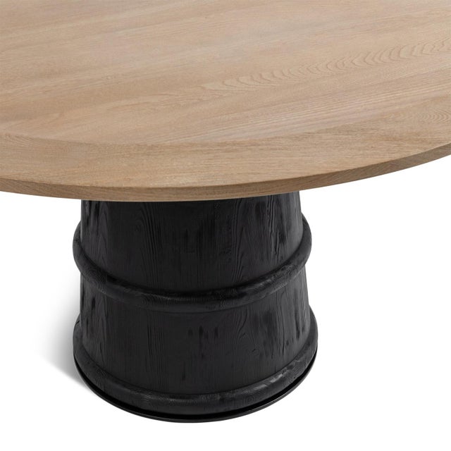 Round elm and pine wood dining table which balances warm natural texture with bold architectural form. The natural elm top...
