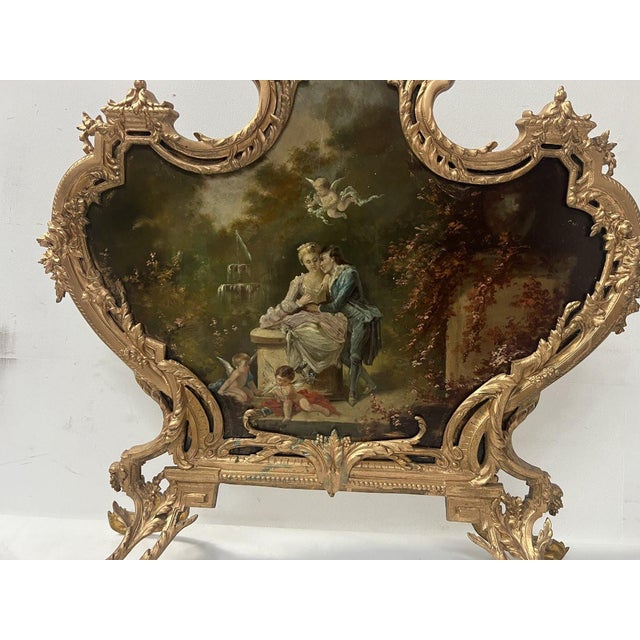 Louis xv style gilt bronze spark guard. The bronze frame rests on four feet. The interior is a metal plate decorated with...