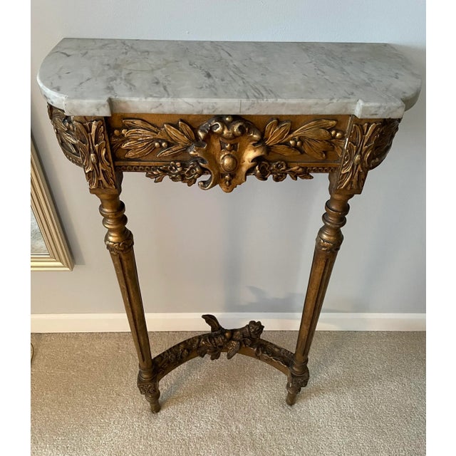 19th Century French Louis XVI Giltwood Marble Top Console Table is petite in size. Flowers, leaves and berries surround a...