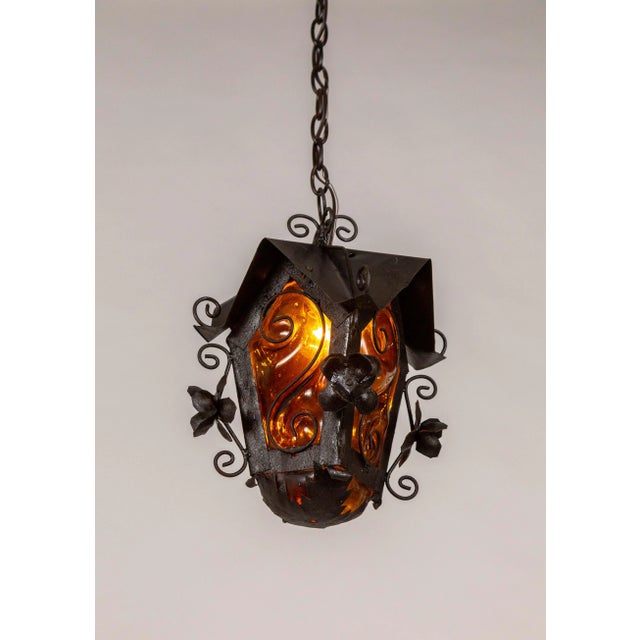 A mid-20th century black metal birdhouse-shaped hanging lantern with a gothic feel. It is detailed with dimensional...