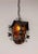A mid-20th century black metal birdhouse-shaped hanging lantern with a gothic feel. It is detailed with dimensional...